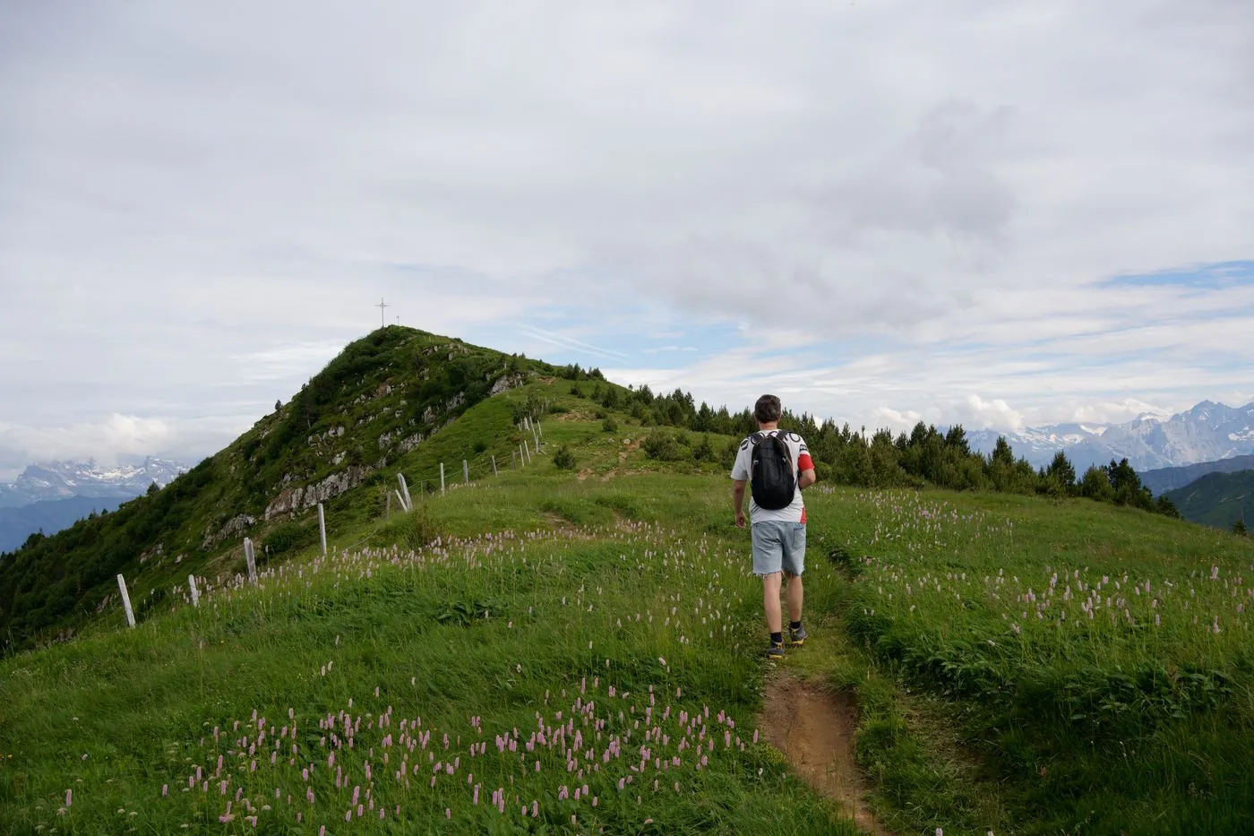 Muž s velkým turistickým batohem na kamenité vyhlídce