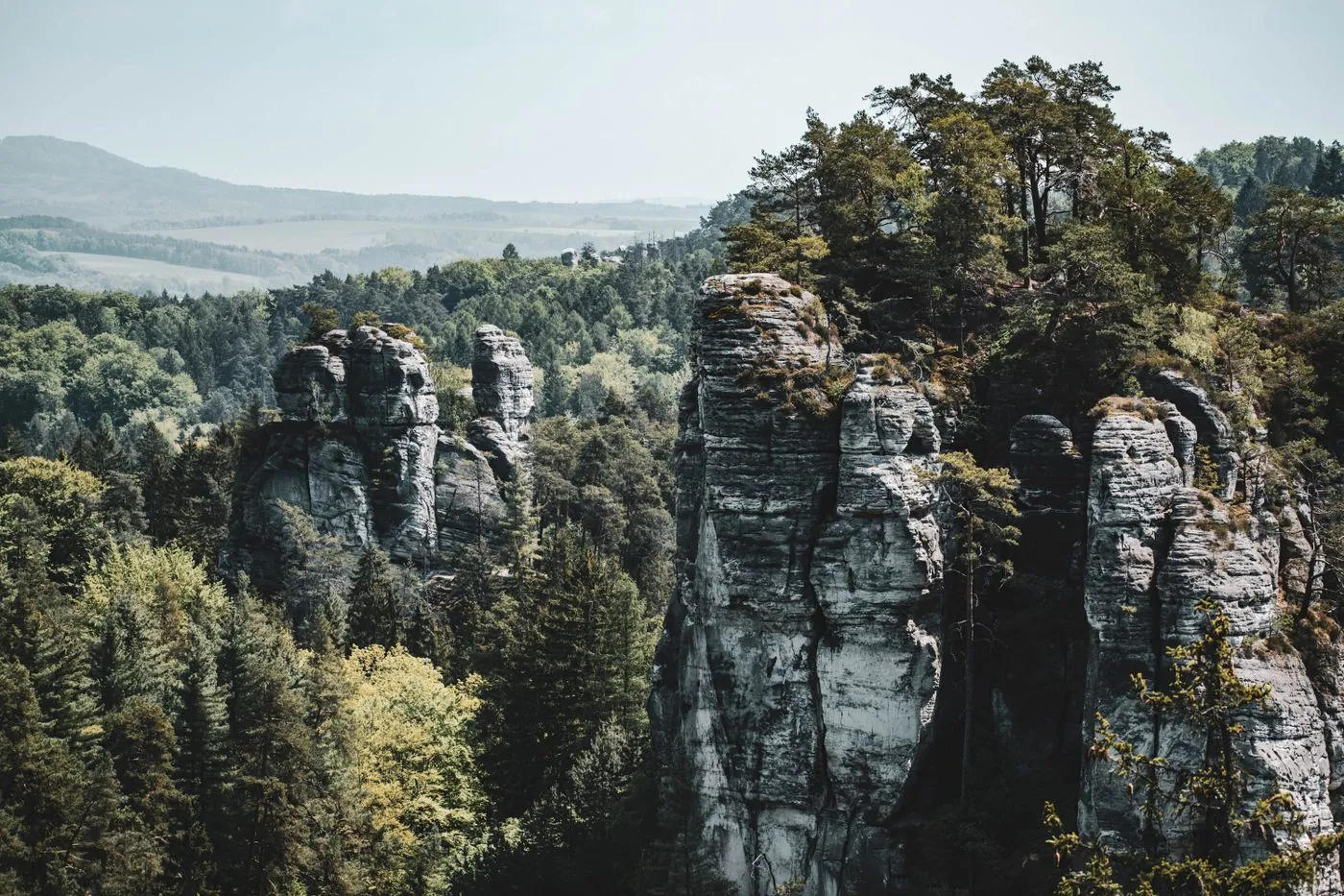 Skalní věže vyčnívající z podzimního lesa