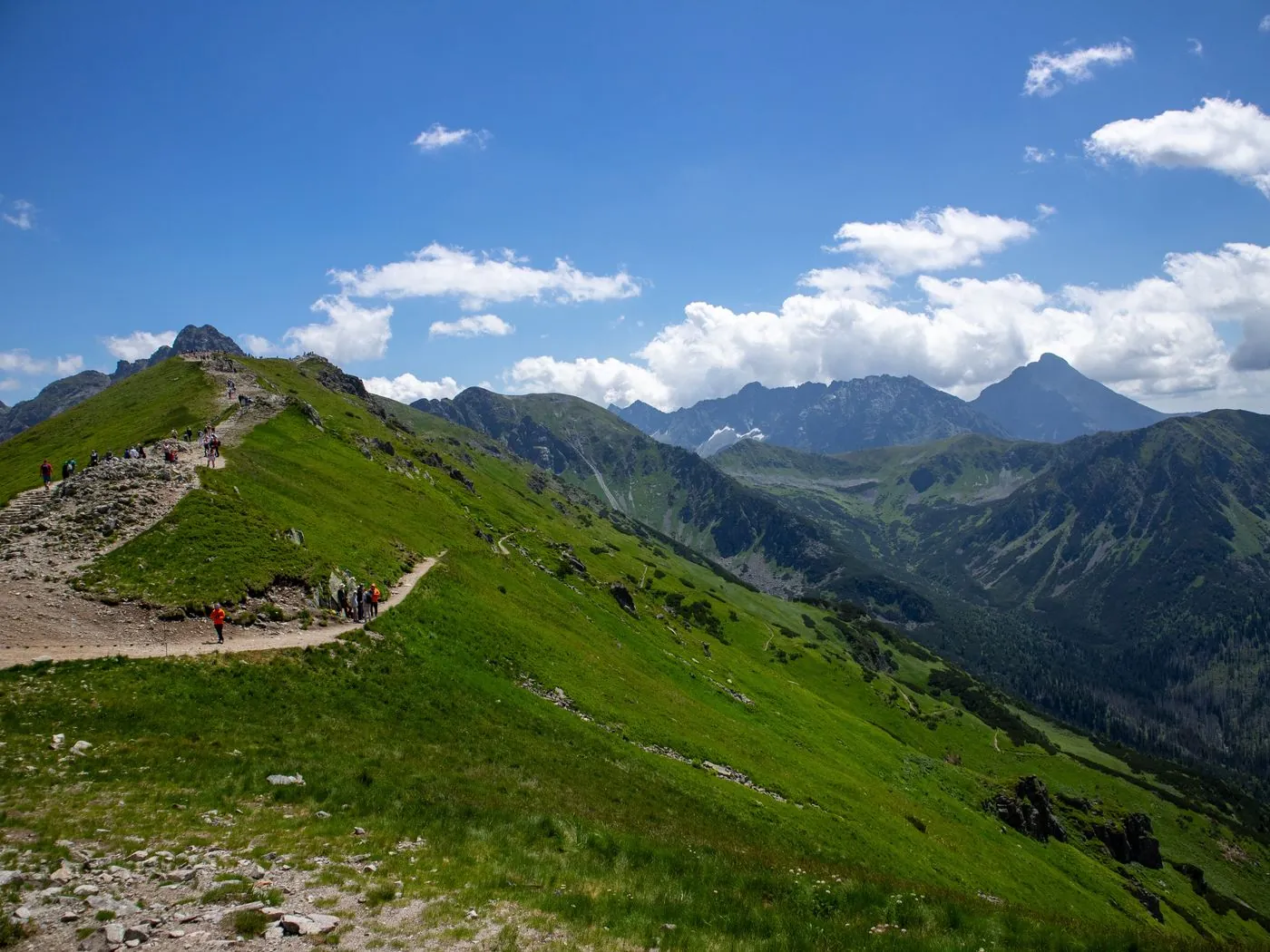 Skupina turistů na zeleném horském hřebeni