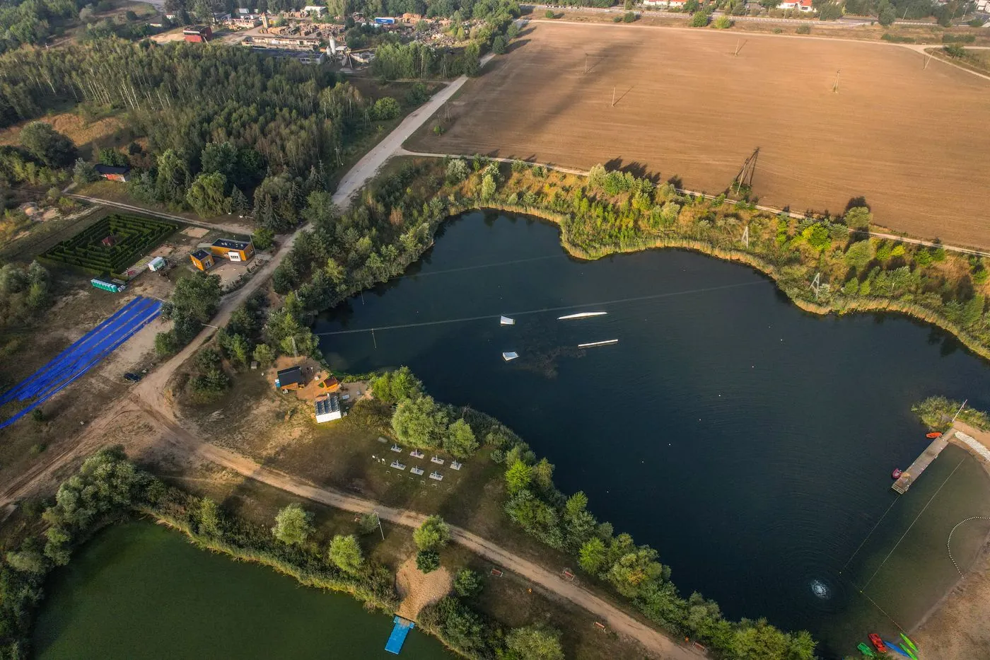 Letecký pohled na jezero obklopené lesem a poli