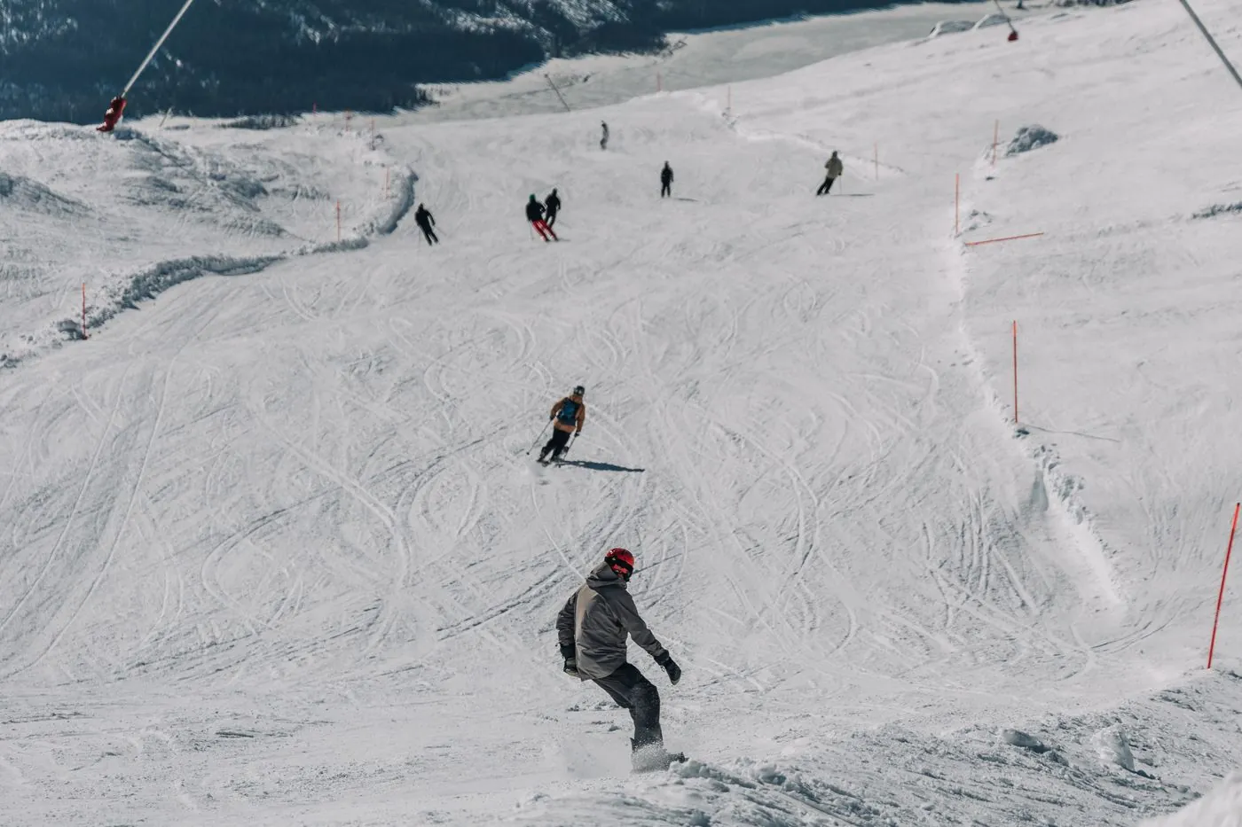 Lyžaři a snowboardista na upravené sjezdovce