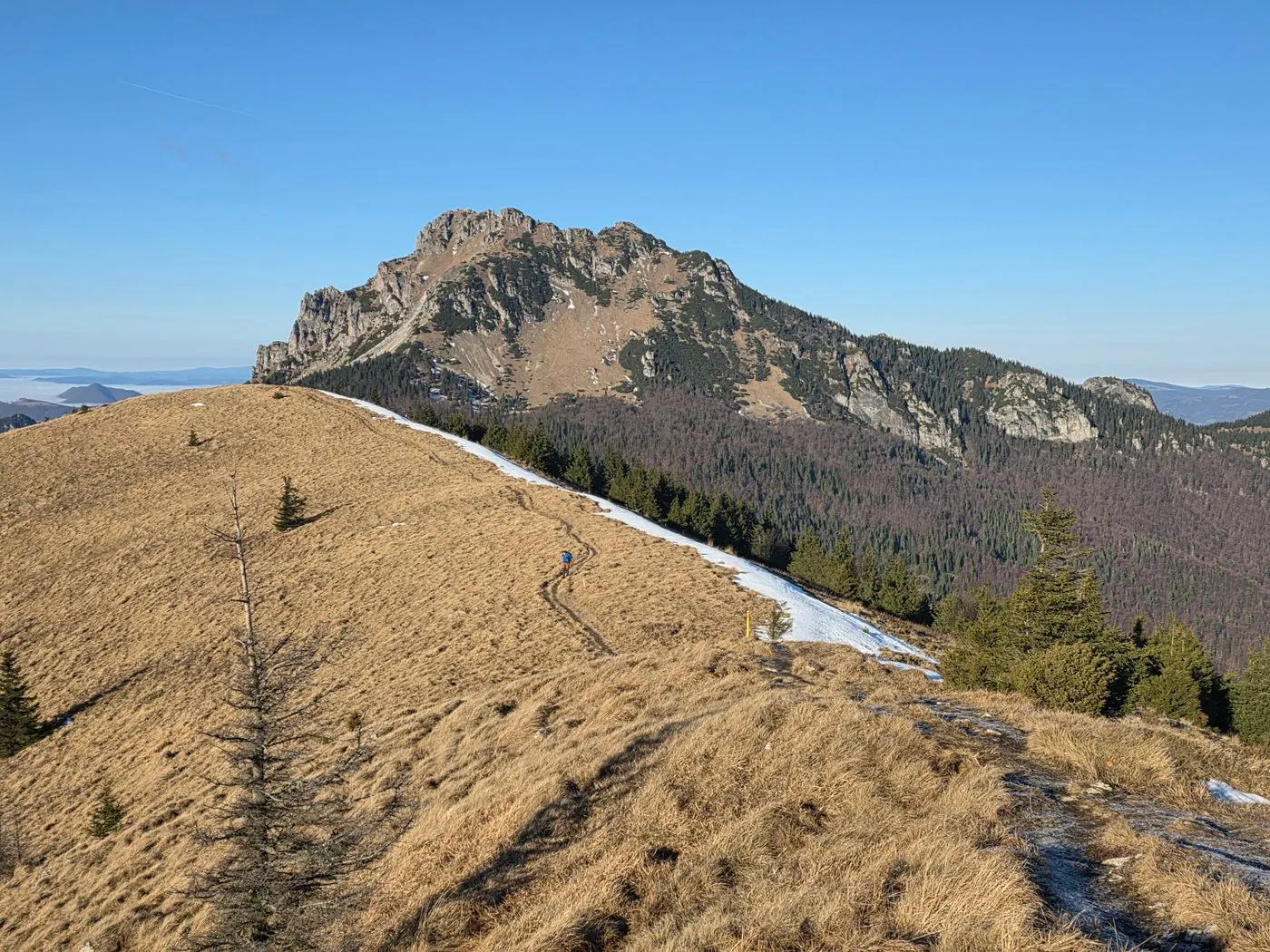 Skalnatý vrchol nad hřebenovou cestou se zbytky sněhu