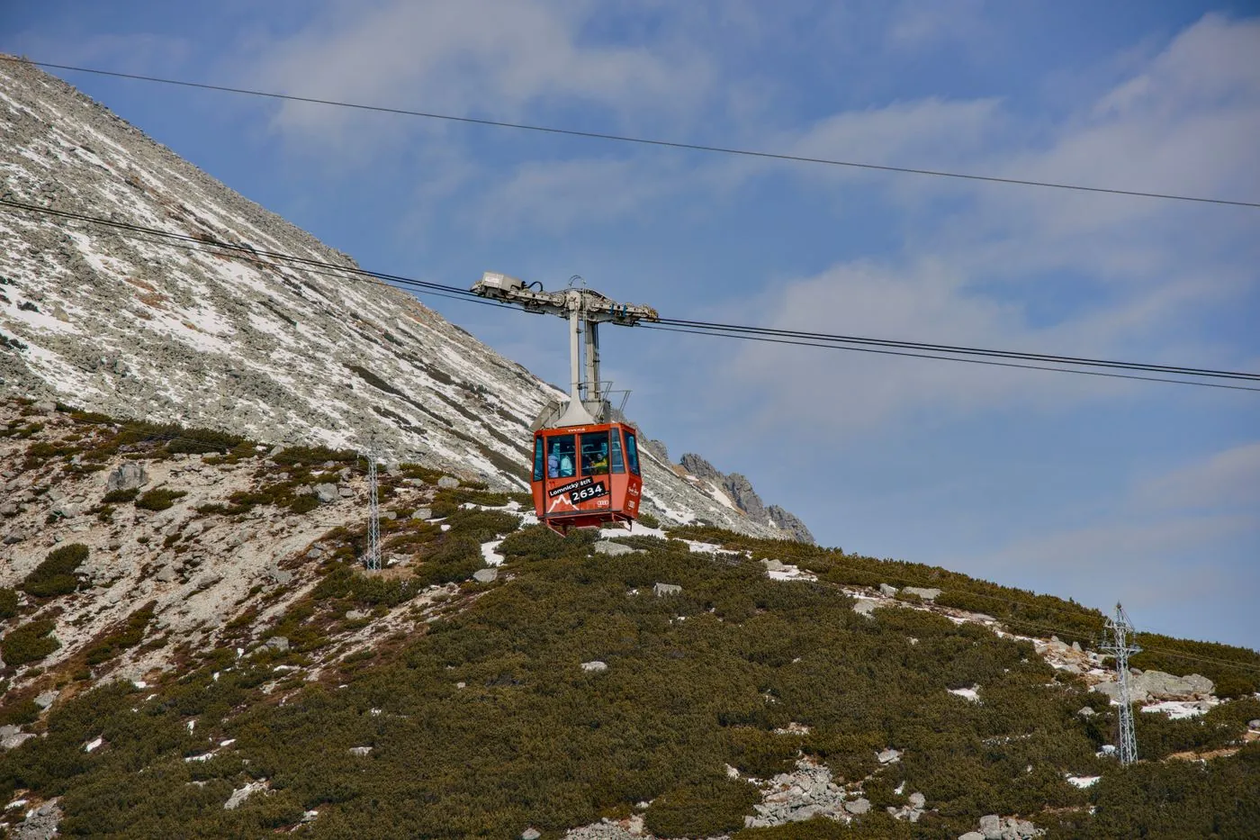 Červená lanovka nad zasněženým svahem