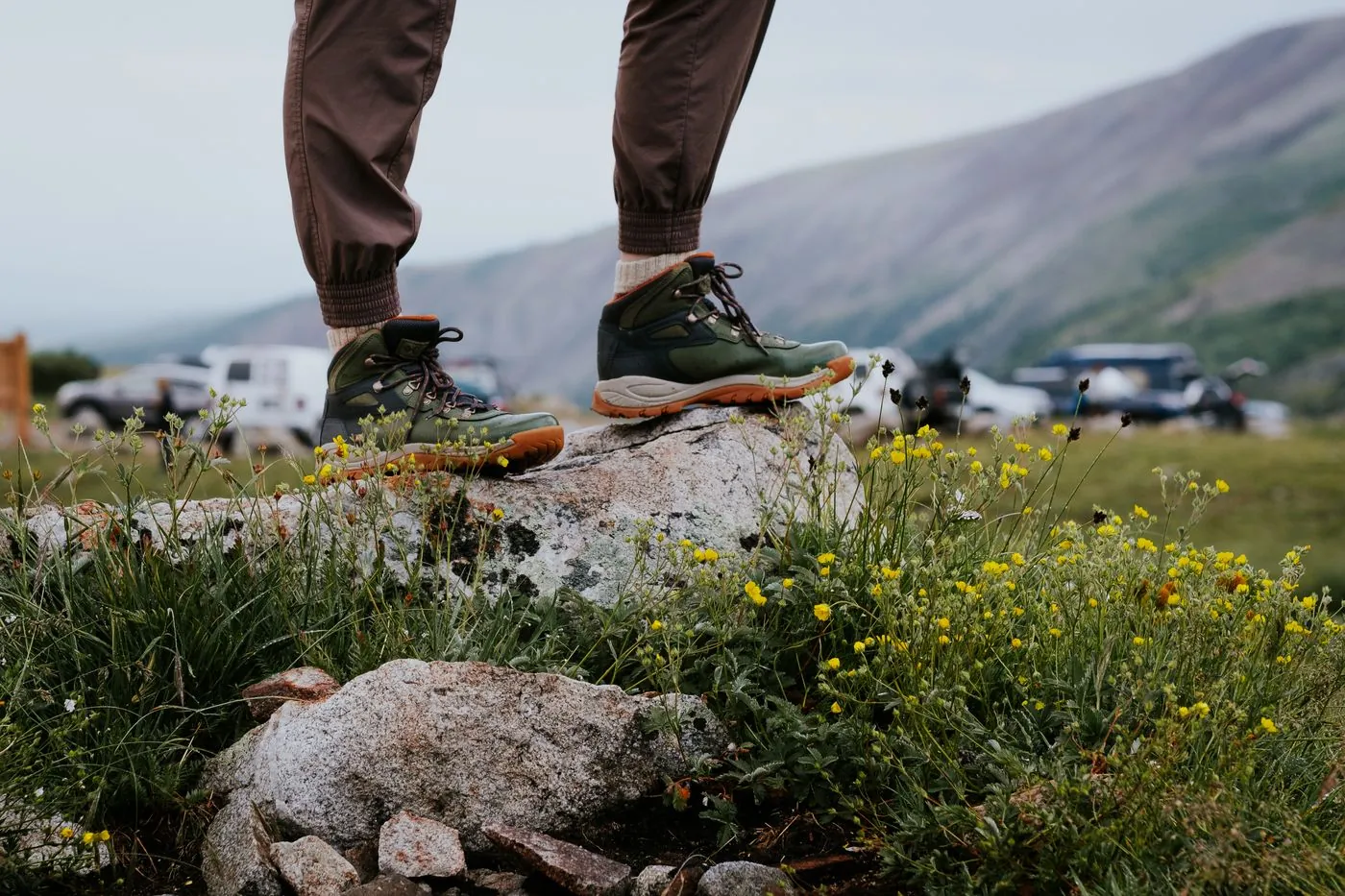 Turistické boty na kameni s horami v pozadí