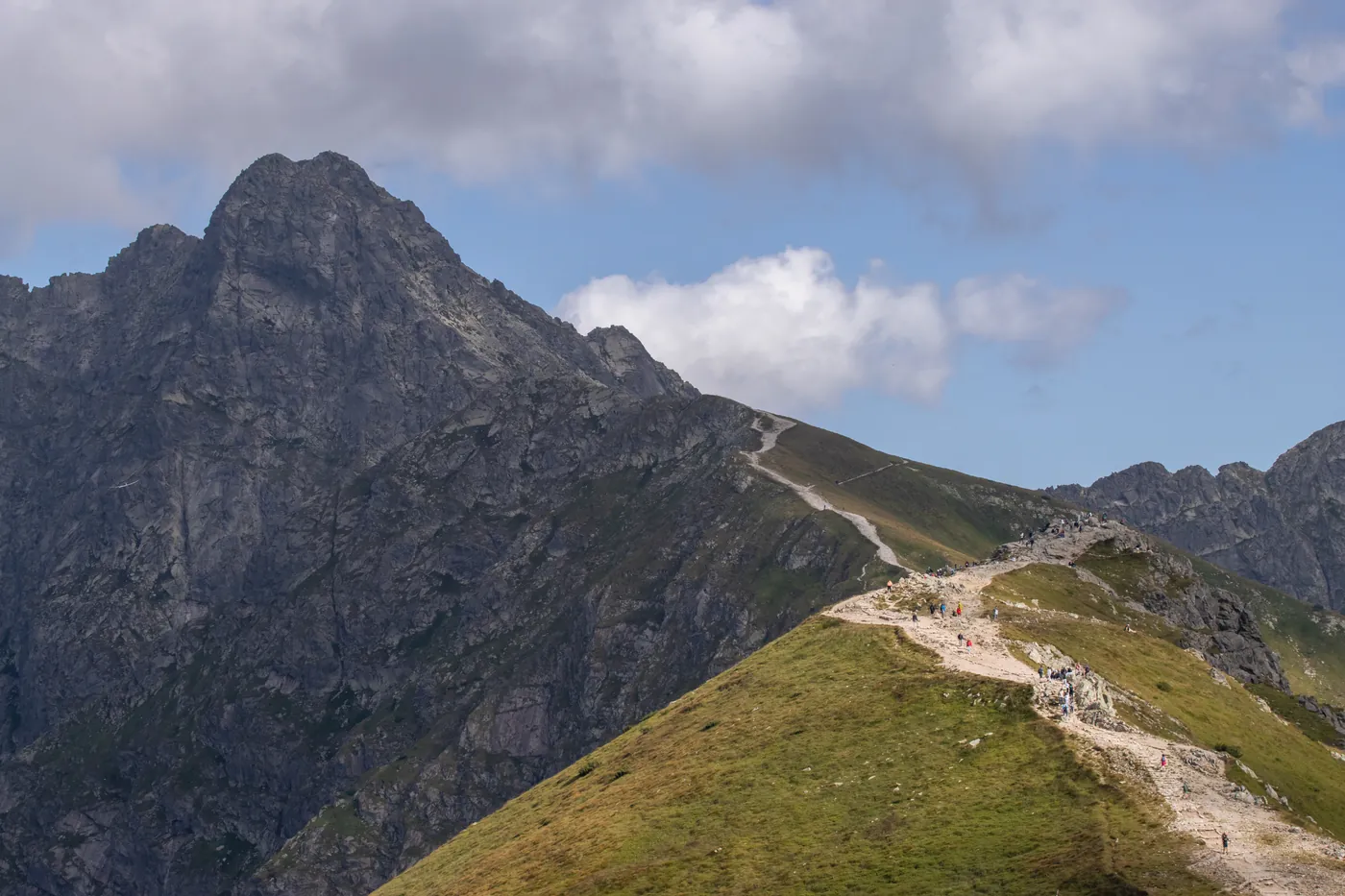 Turisté na hřebenové cestě pod skalnatým štítem